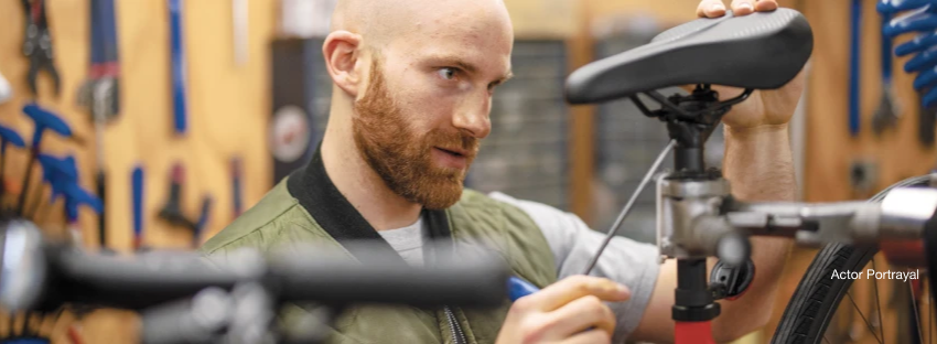 Man fixing bicycle seat in a workshop